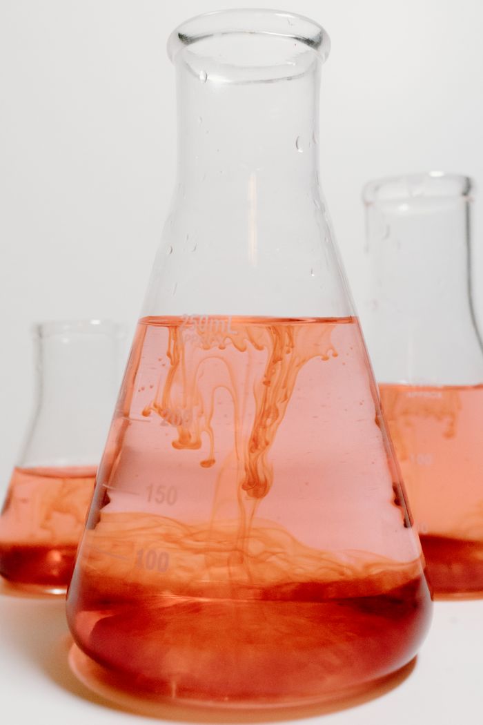 Close-up of red solution in glass beakers, ideal for science themes.